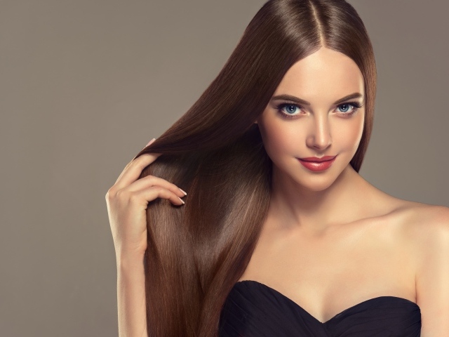 Красивая нежная длинноволосая голубоглазая девушка на сером фоне