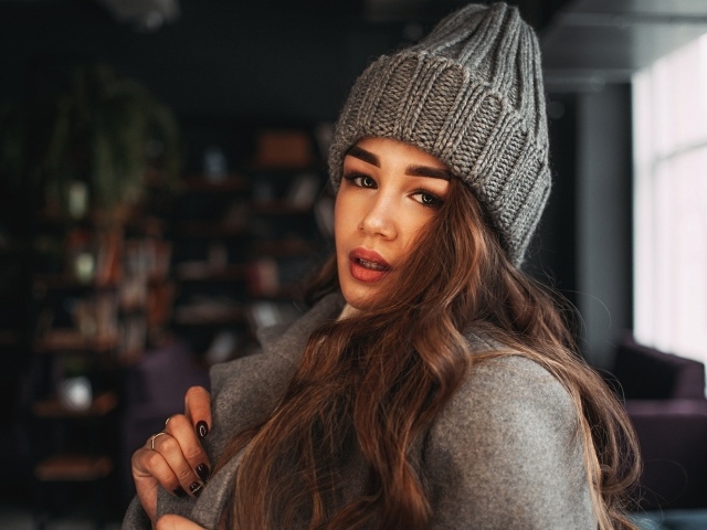 Красивая молодая девушка в пальто в вязаной шапке