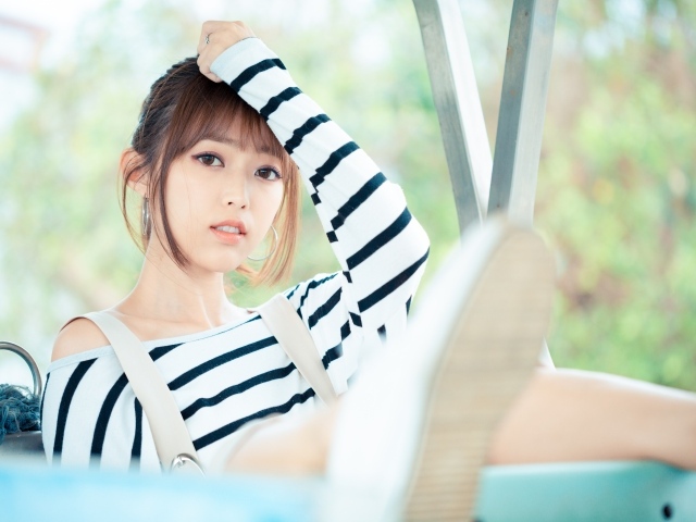 Кареглазая девушка азиатка в полосатом свитере