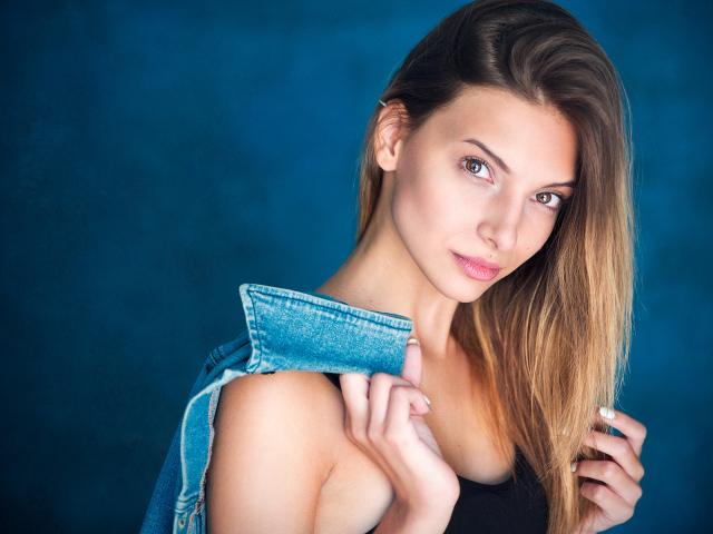 Кареглазая шатенка с джинсовой курткой в руке