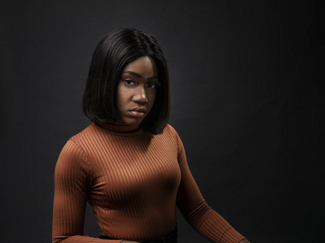Темнокожая девушка с короткой стрижкой на сером фоне