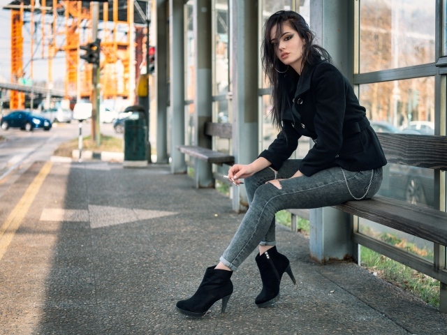 Девушка неформалка сидит на автобусной остановке