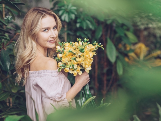 Улыбающаяся блондинка с букетом хризантем в руках