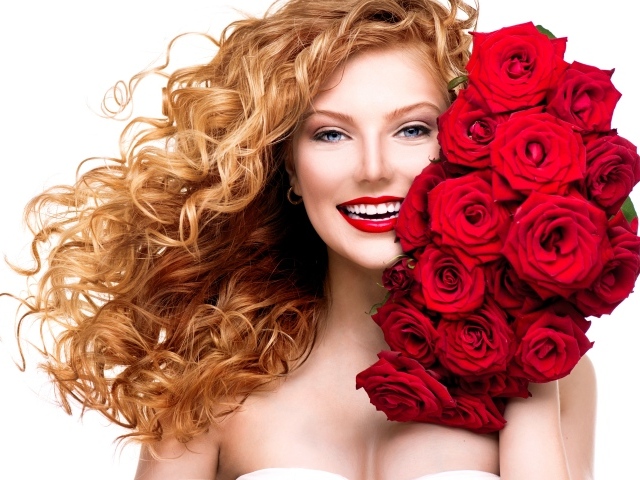 Улыбающаяся голубоглазая рыжеволосая девушка с букетом красных роз 
