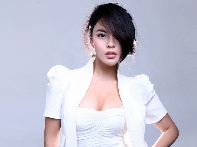 Стильная девушка азиатка в белом костюме на сером фоне