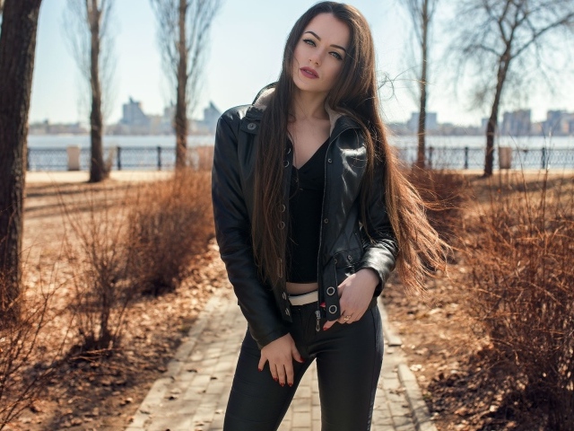 Стильная девушка в черной куртке в парке 