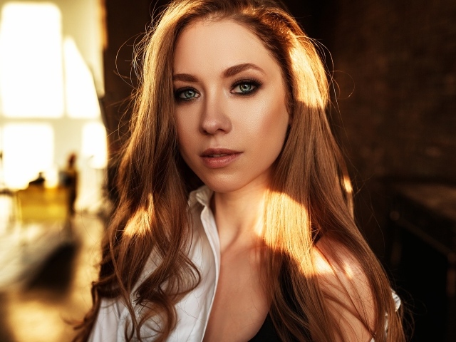 Лучи солнца нападают на волосы голубоглазой шатенки 