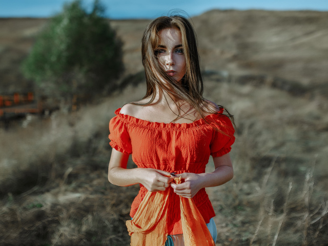 Ветер развивает волосы красивой девушке шатенке 