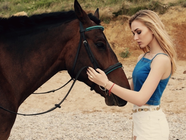 Молодая девушка блондинка с коричневой лошадью 