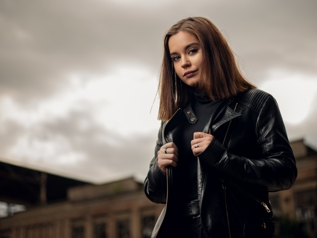 Молодая девушка в кожаной куртке на фоне грозового неба