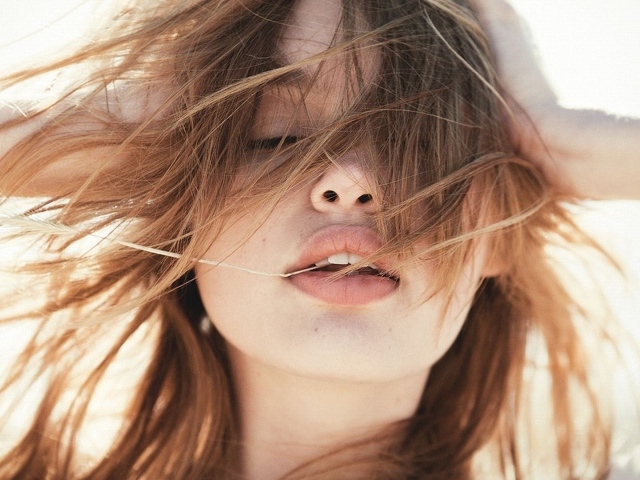 Молодая девушка с распущенными волосами на ветру