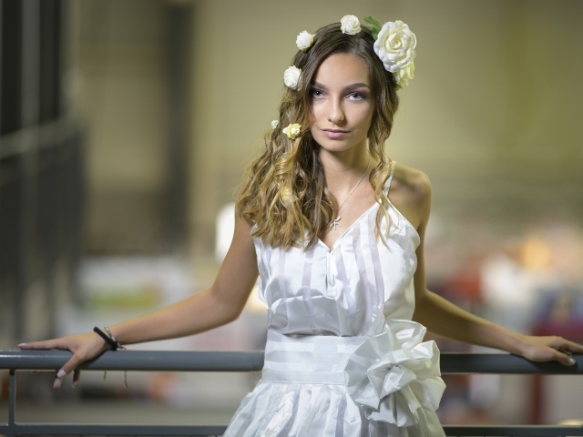 Красивая девушка в белом платье с цветами в волосах 