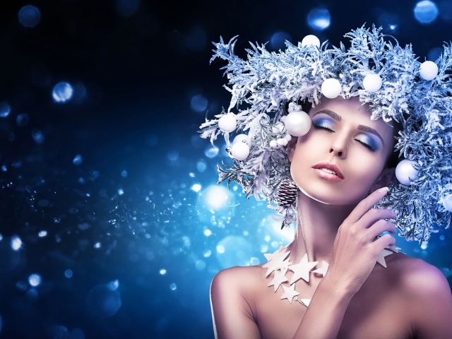 Красивая девушка с закрытыми глазами в новогоднем венке на голове