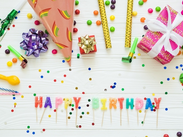 Надпись с Днем рождения на столе с подарками и украшениями