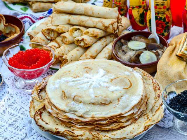 Вкусные праздничные угощения с блинами и икрой на столе к празднику Масленица