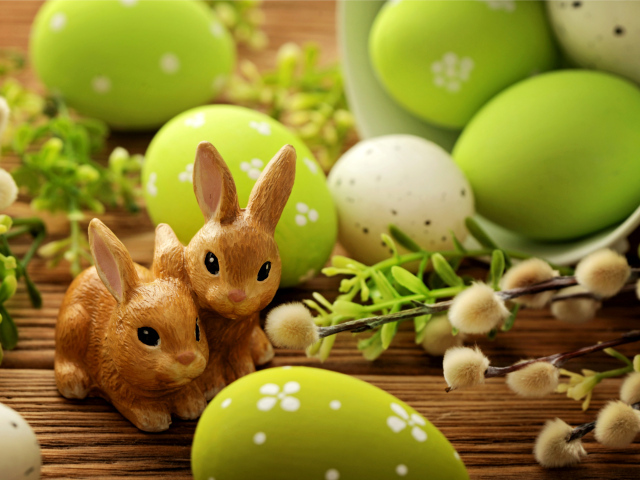 Крашеные яйца с веткой вербы и фигурками кроликов на праздник Пасха