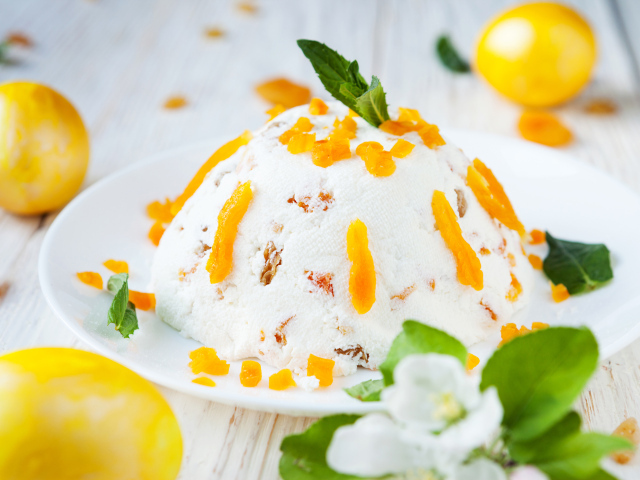 Сладкая творожная пасха с курагой на столе с крашеными яйцами