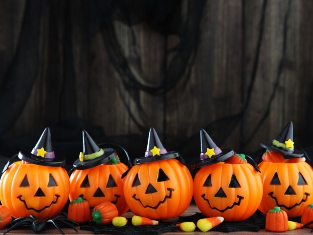 Забавные тыквы в черных шляпах на праздник Хэллоуин 