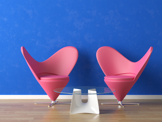 Два розовых кресла и стеклянный столик у синей стены 