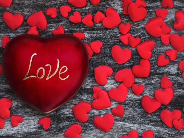 Большое красное сердце на деревянном фоне с маленькими сердечками