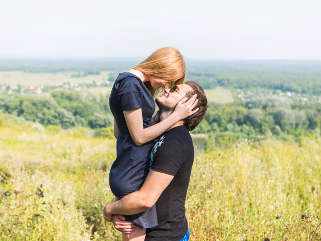 Влюбленная пара обнимается на поле 