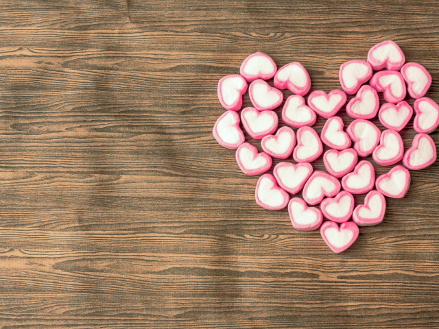 Сердце из конфет на деревянном столе