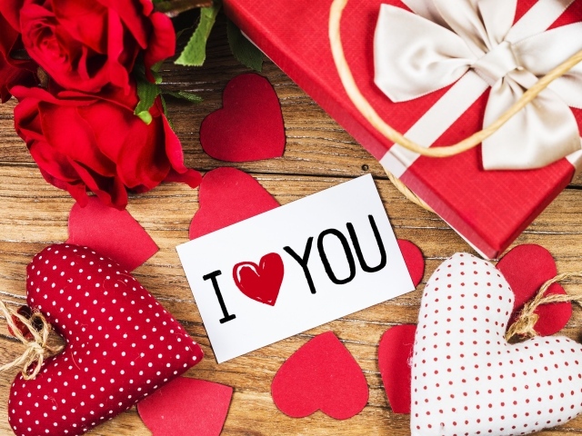 Сердечки, цветы и подарок на столе с запиской