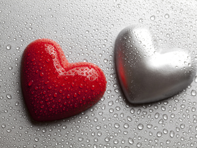 Красное и серое сердце на сером фоне в каплях воды