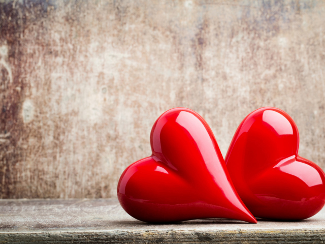 Два ярких красных сердца на сером фоне