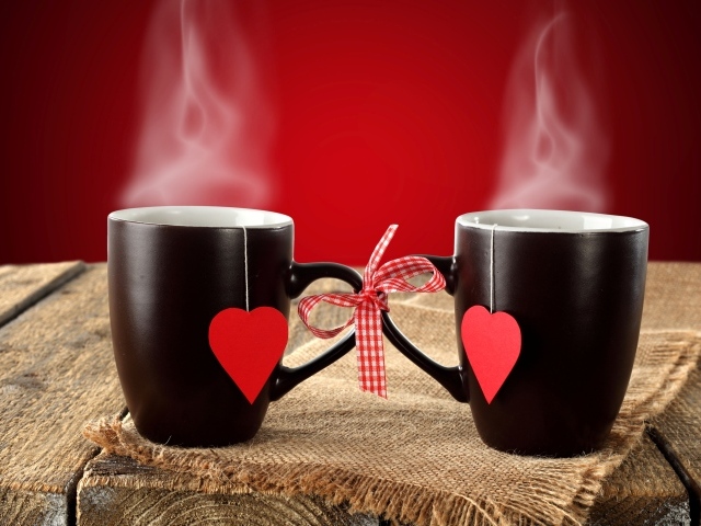 Две чашки горячего чая связаны бантом 