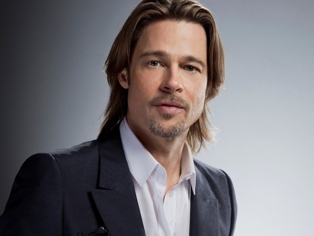 Актер Брэд Питт в костюме на сером фоне