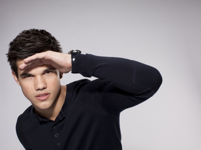 Красивый парень, актер Тейлор Лотнер на сером фоне