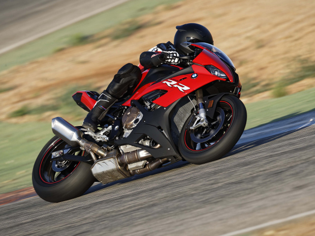 Гонщик на мотоцикле BMW S1000 совершает крутой поворот