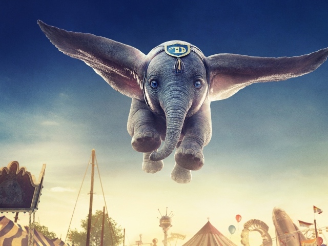 Серый маленький слоненок Дамбо в воздухе 
