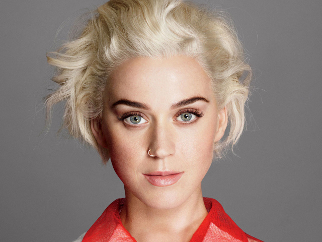 Певица Кэти Перри с короткой стрижкой на сером фоне