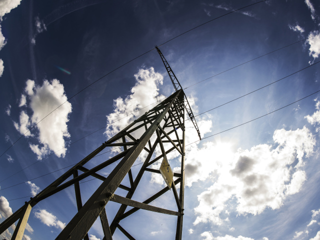 Столб линии электропередач на фоне голубого неба с облаками