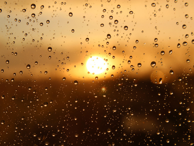 Капли дождя на стекле при свете солнца