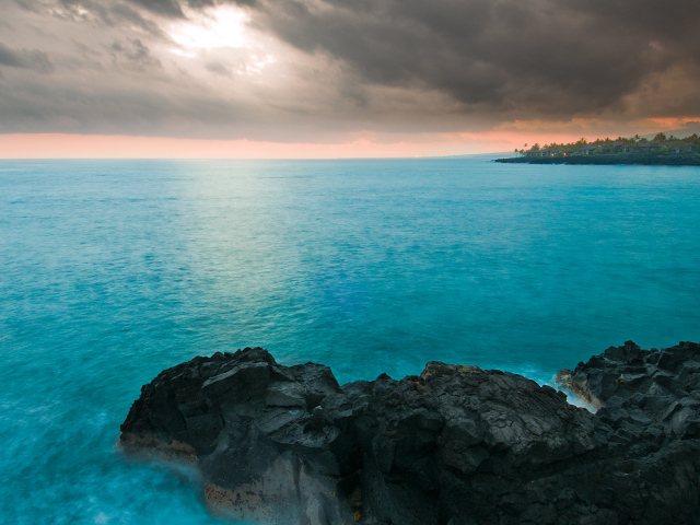 Камни в голубой воде океана под пасмурным небом