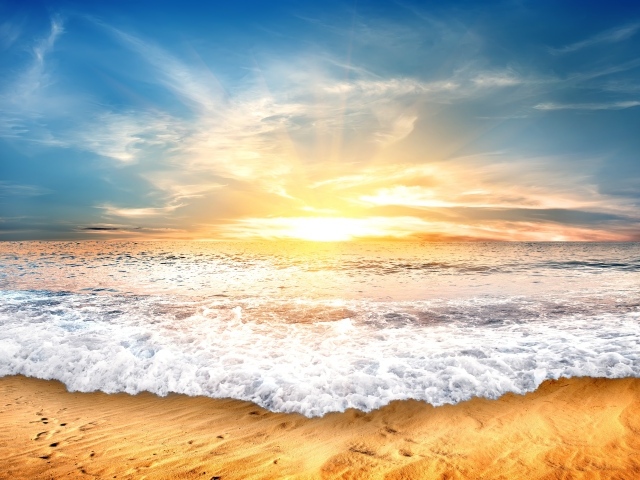 Белые волны на желтом песке на закате солнца 