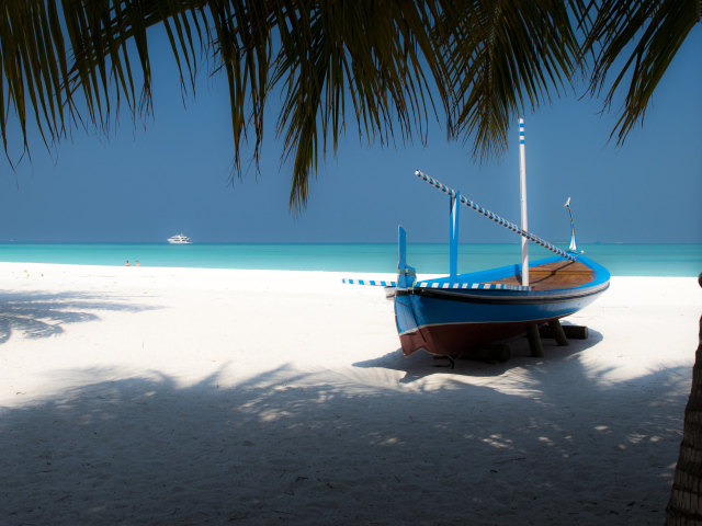 Лодка на белом песке у океана в тропиках