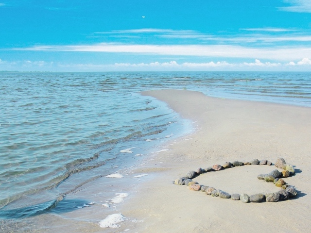 Сердце из камней на берегу теплого моря летом