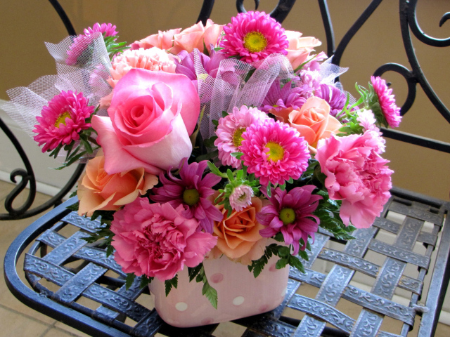 Красивый букет стоит на железном стуле