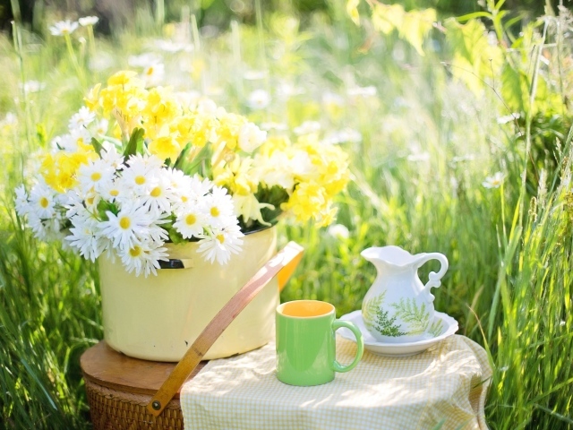 Букет цветов в кастрюле стоит на корзине 