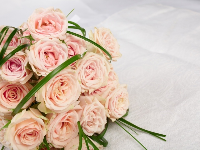 Букет розовых роз на белом покрывале 