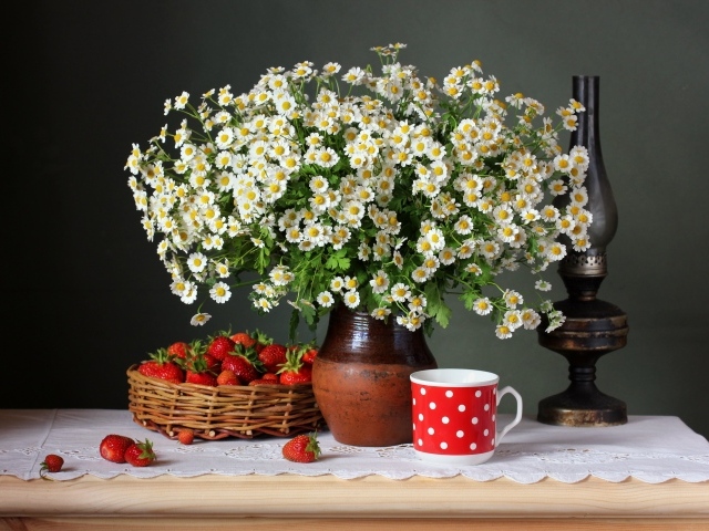 Большой букет ромашек на столе с клубникой