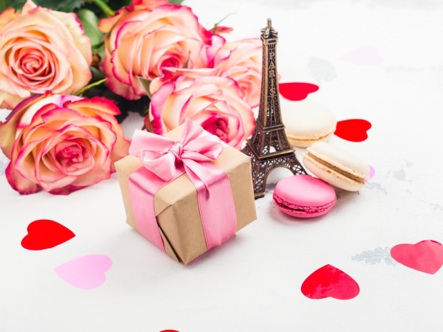 Букет роз на столе с фигуркой Эйфелевой башни и подарком