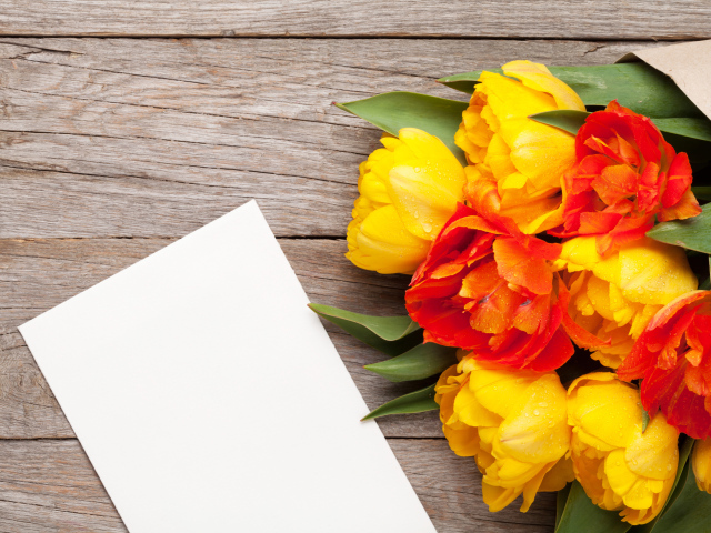 Букет желтых тюльпанов на столе с листом бумаги
