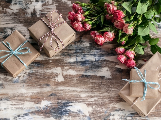 Подарочные коробки на деревянной поверхности с букетом роз