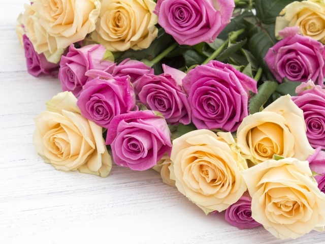 Розовые и белые розы на белом столе 