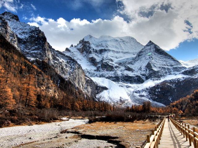 Мост у подножия заснеженных величественных гор